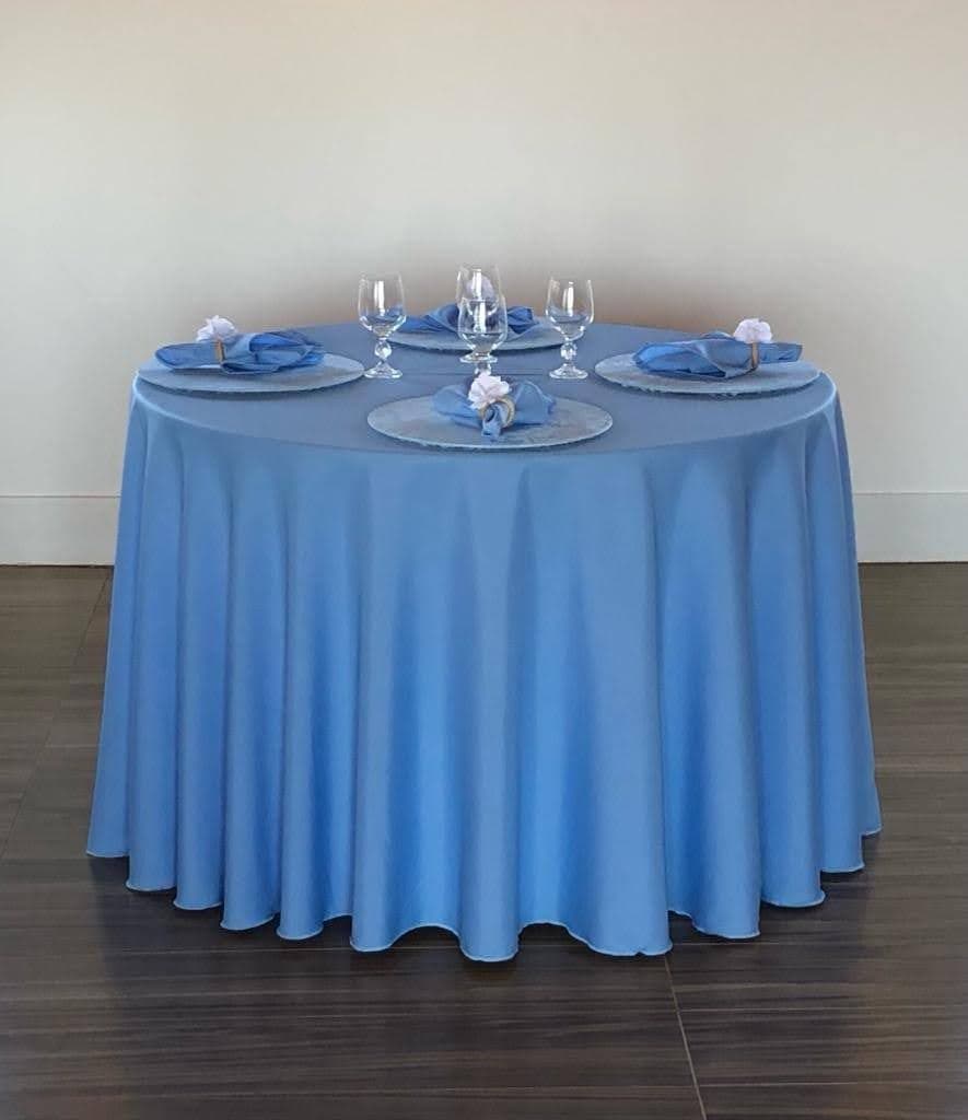 Mesa redonda com toalha azul serenity longa e mesa posta elegante