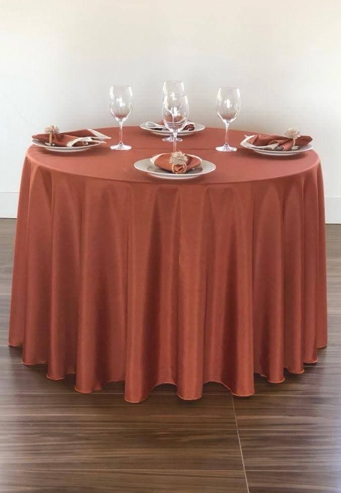 Mesa redonda com toalha terra cota longa e mesa posta