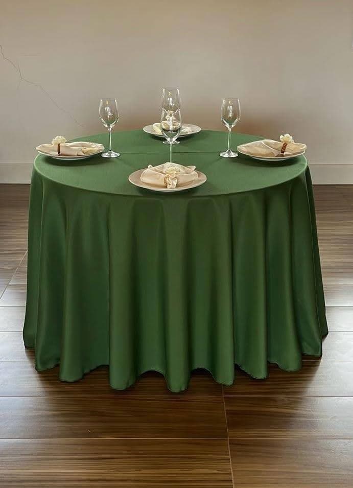 Mesa redonda com toalha verde musgo longa e arranjo formal